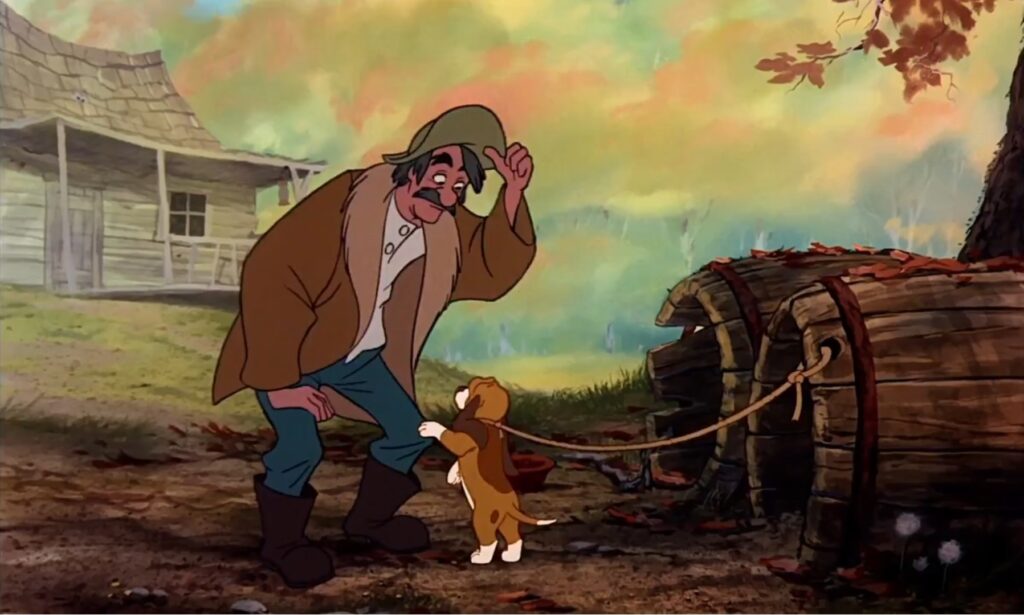 Amos Slade trzyma szczeniaka Miedziaka, przygotowując go do roli psa myśliwskiego.