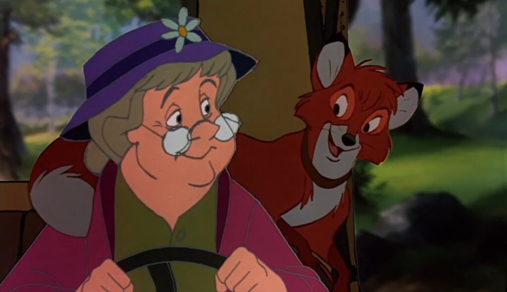 Wdowa Tweed ze smutkiem prowadzi auto, w którym siedzi lis Tod – scena wywożenia do lasu.